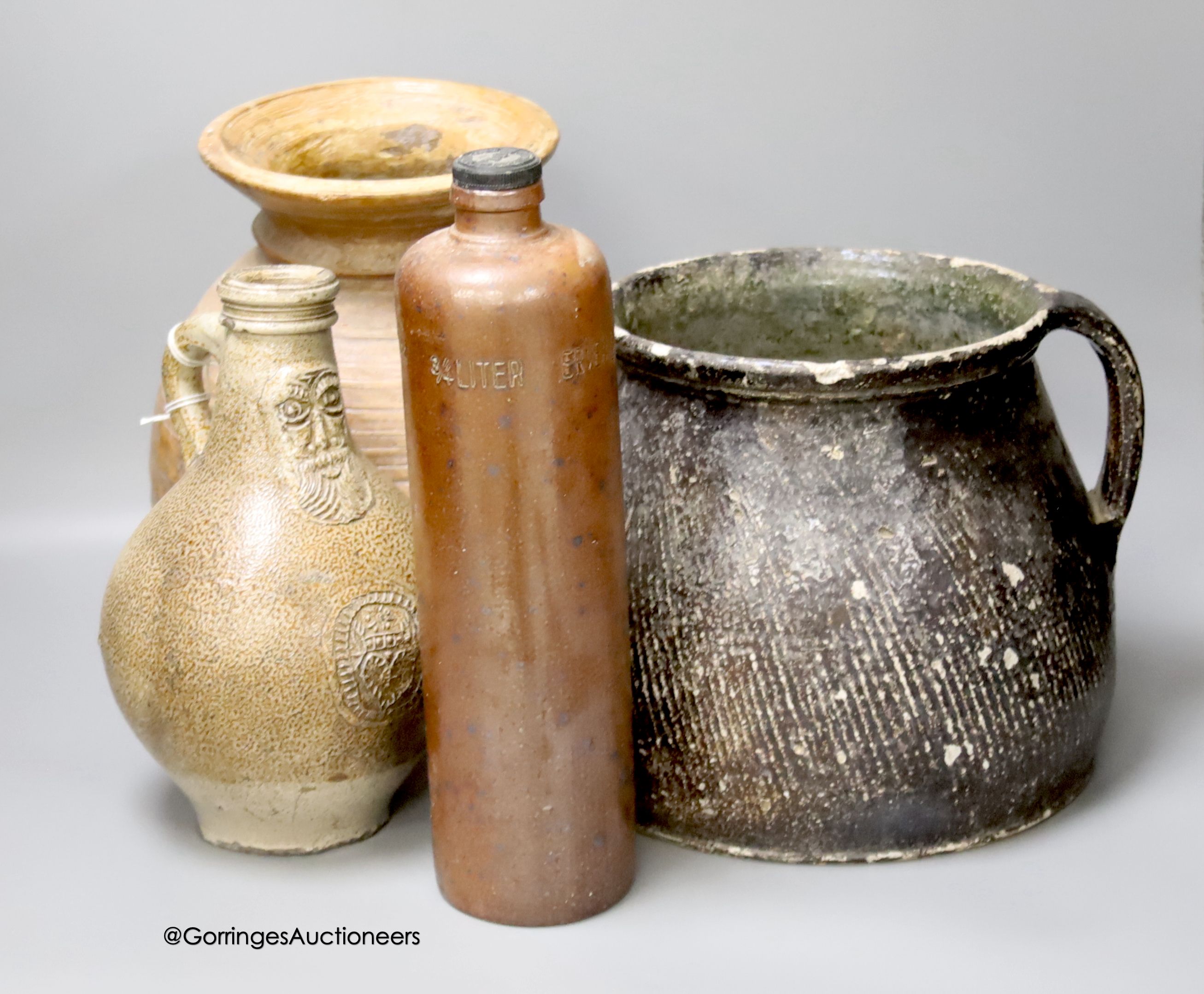 A 17th century continental Tiger ware Bellarmine, 23cm, together with a two handled earthenware bowl, a turned wood bowl and a cylindrical stoneware flask